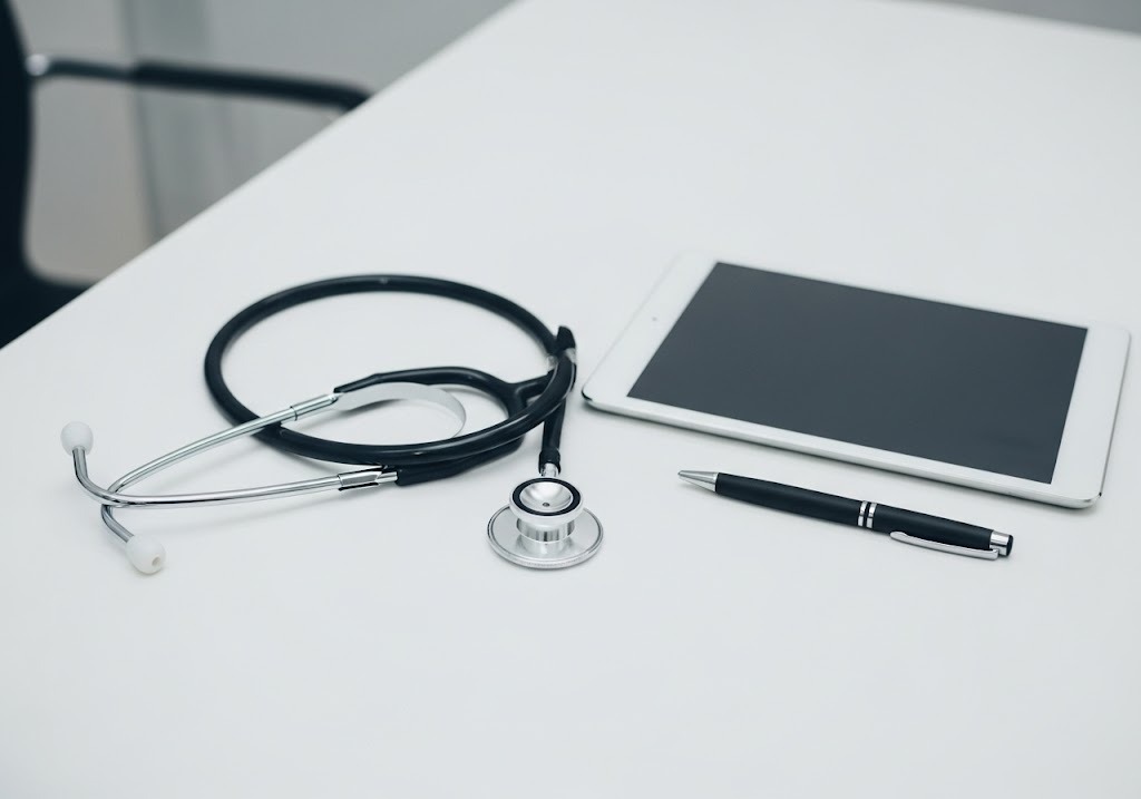 stethoscope, tablet, and pen on table