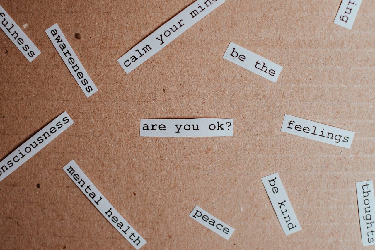 cutouts of printed words and phrases related to mental health on a cardboard surface