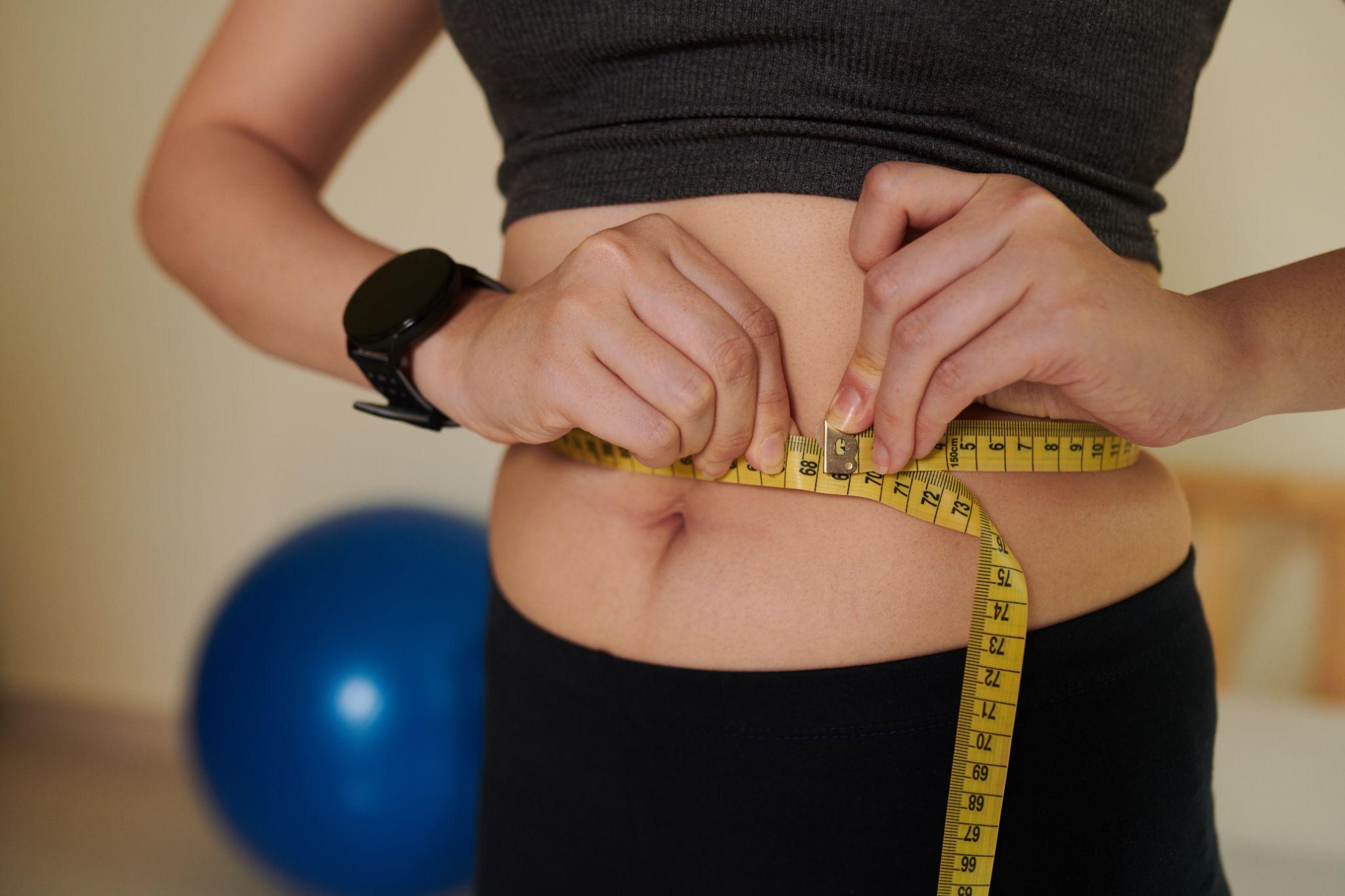 woman measuring her waist