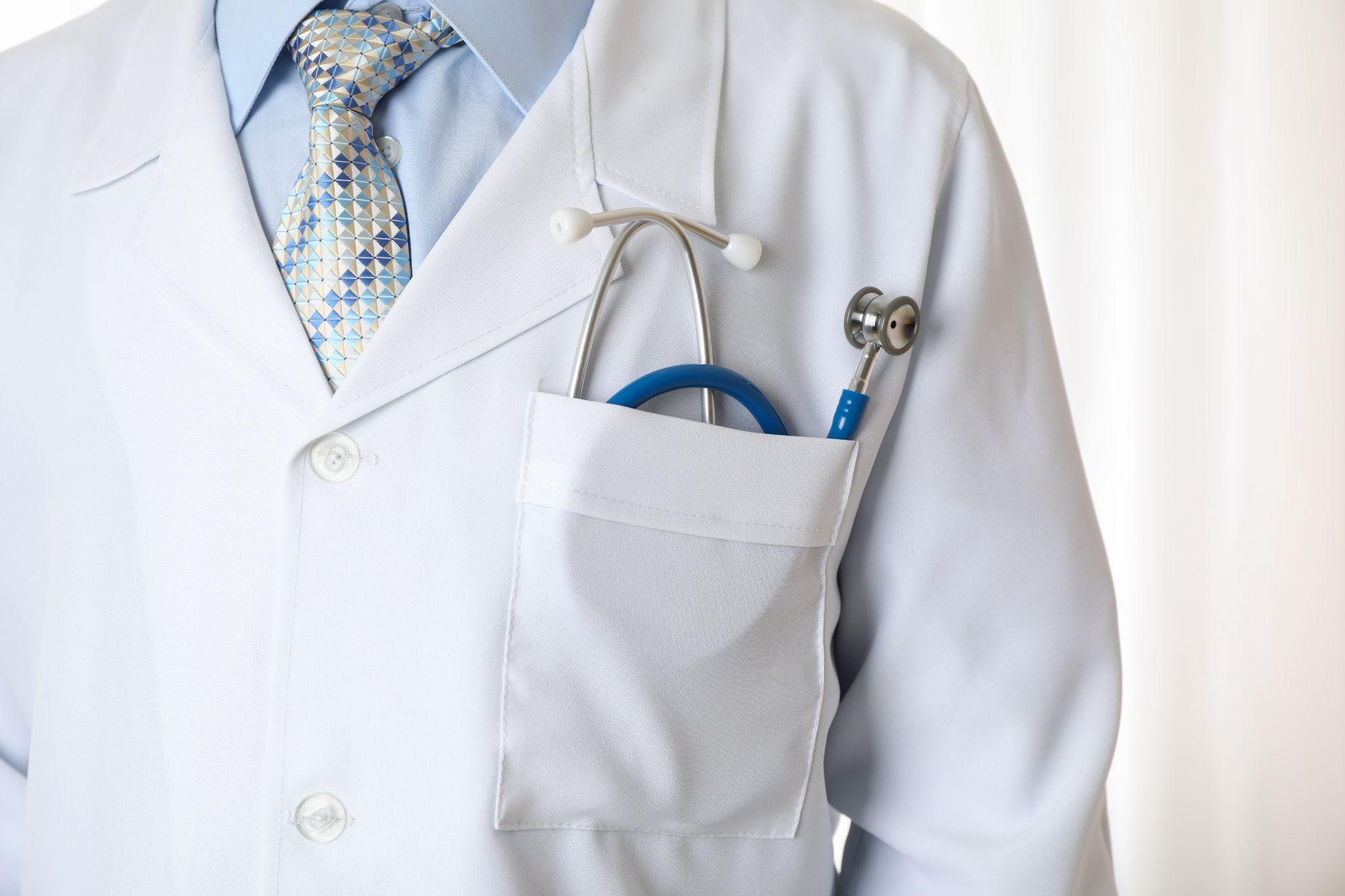 Doctor in lab gown with blue stethoscope, close up