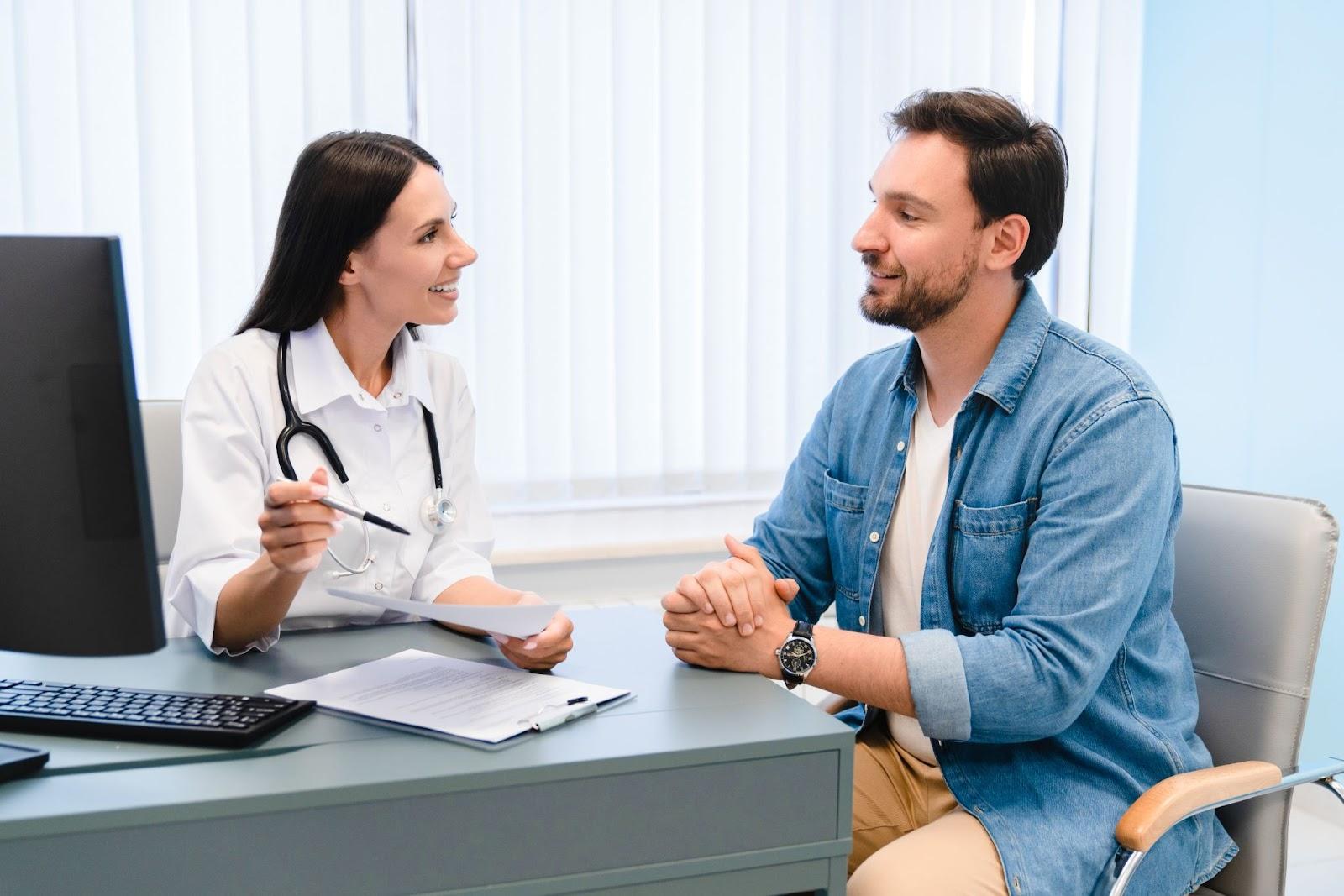 Smiling doctor talking with a patient during a friendly clinic visit.