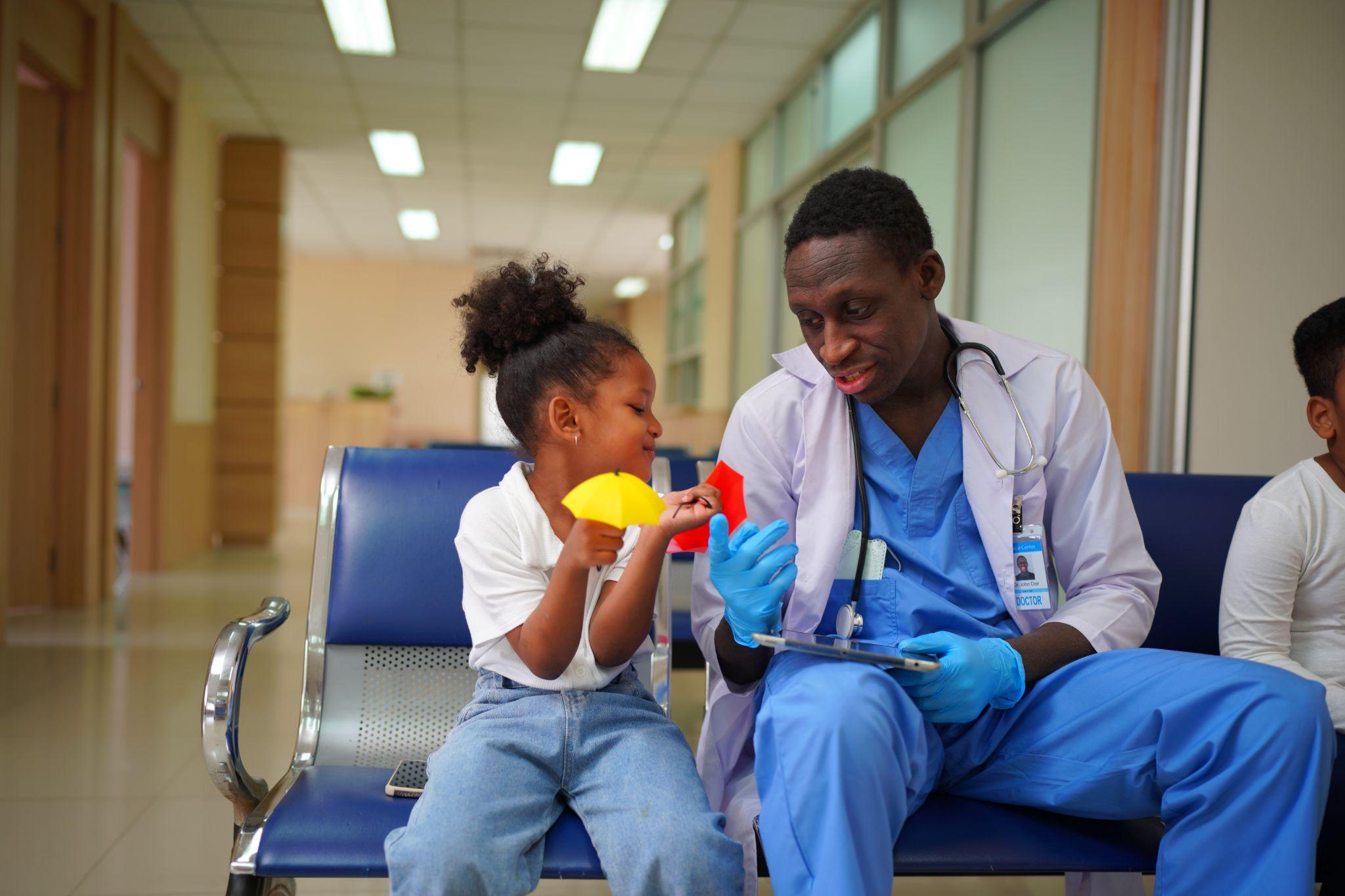 Doctor talking with a young patient in a clinic, showing care and community support.